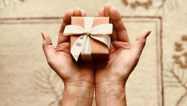 A hand holding a wrapped gift