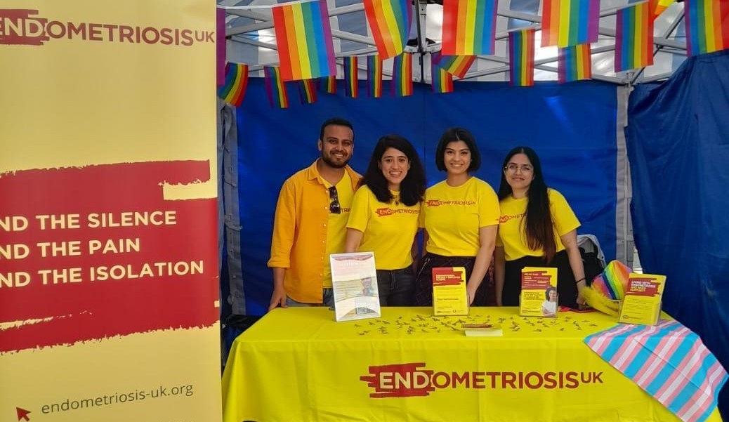 four volunteers at Pride infromation stand. With decorations and leaflets.