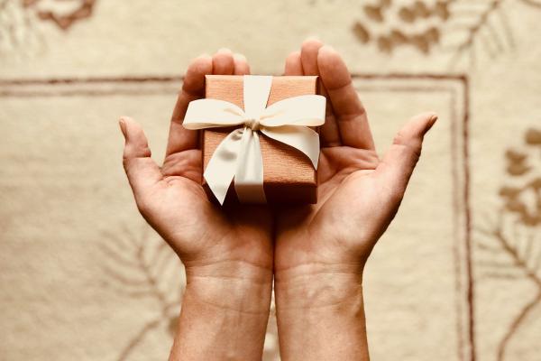 A hand holding a wrapped gift